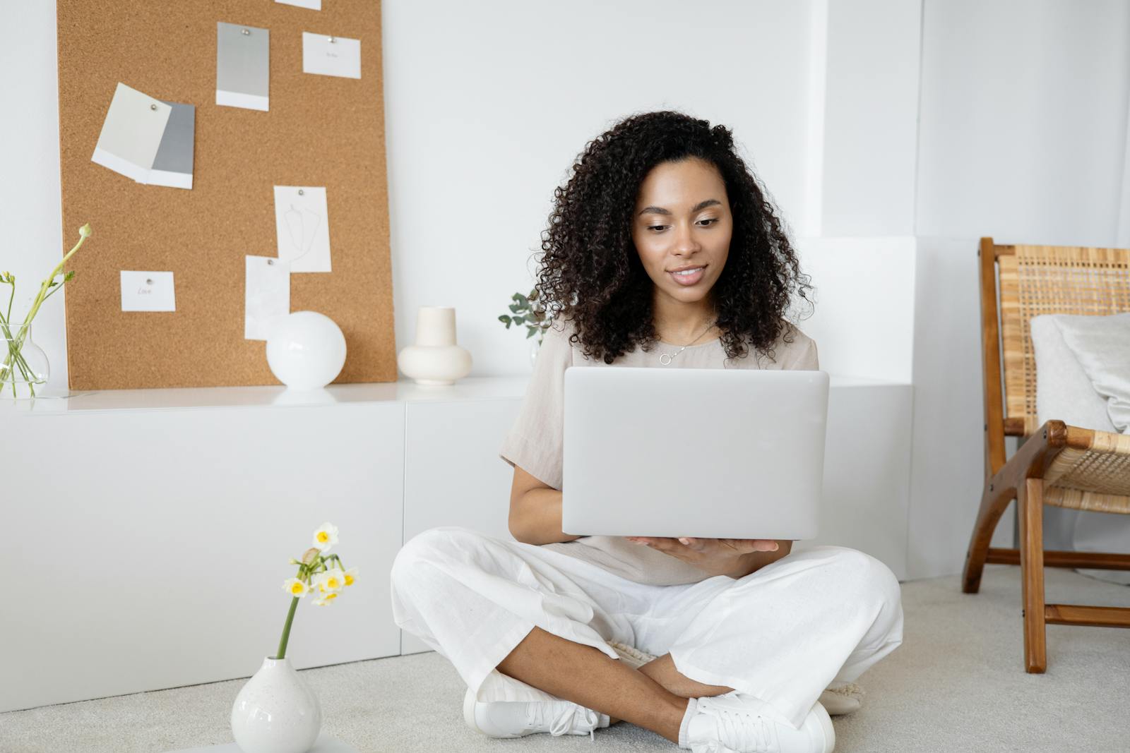 Photo by Anna Nekrashevich Young woman with curly hair working on her laptop in a cozy home setting, exuding confidence and focus.